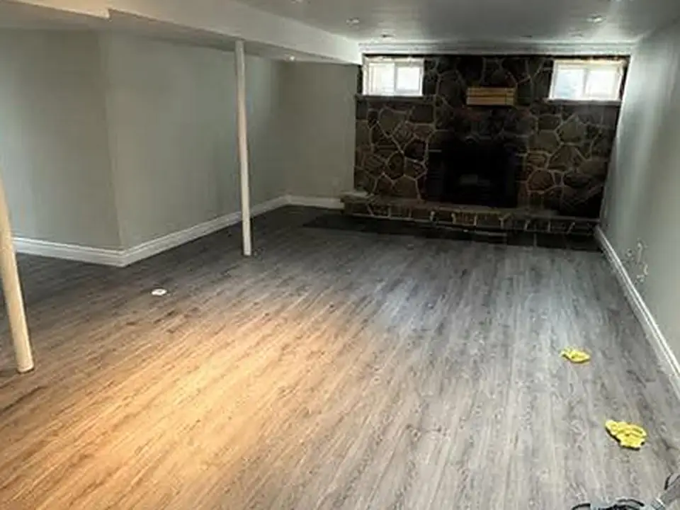 Finished basement with debris on the floor, before cleaning