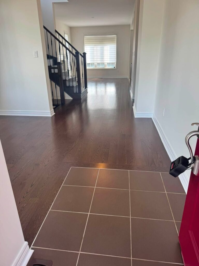 Clean hardwood and tile floors in the front hall of an empty home
