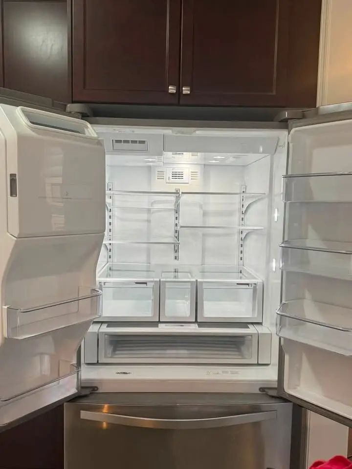Refrigerator interior with clean, empty shelves and drawers, after cleaning